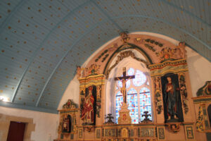 Vue du retable de la chapelle Saint Guénolé, en bois peint et doré, ainsi que de la voute en bois peinte en bleu clair et parsemée d’étoiles dorées